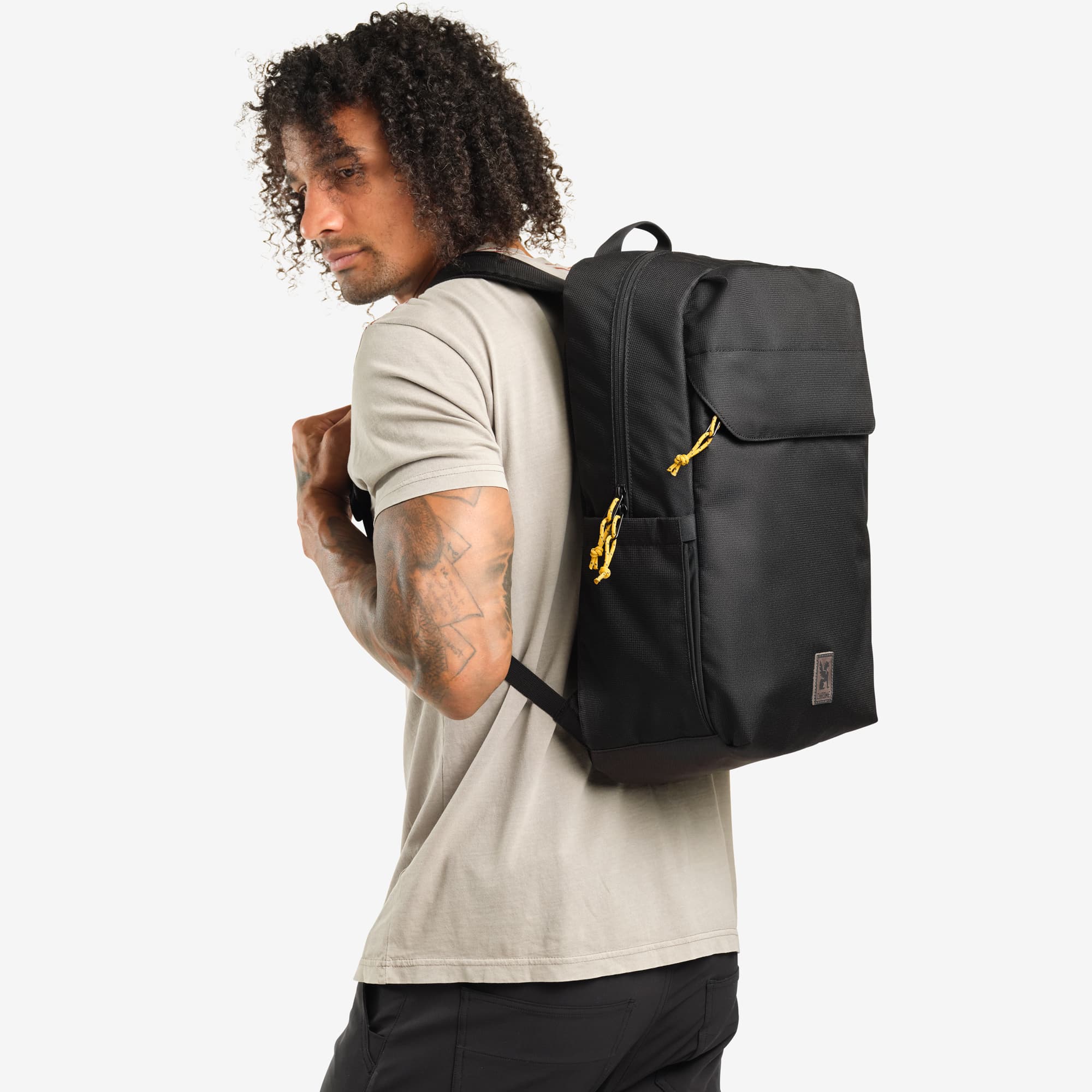 Ruckas 23L Backpack in black worn by a man #color_black